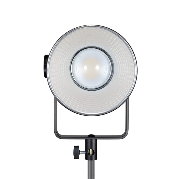 Pyöreällä heijastimella ja keskuslampulla varustettu Godox SL150R RGB LED -videovalaisin on asennettu säädettävään jalustaan suoraan eteenpäin valkoista taustaa vasten.