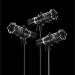Kolme mustaa Godox Spotlight Attachment MLP19K - ML30/ML60 - LED-valo -yksikköä on asennettu jalustalle kiinteää mustaa taustaa vasten, ja jokainen niistä on suunnattu eri kulmaan valokuva- tai videovalaistusta varten.