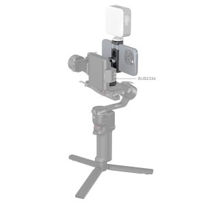 SmallRig 4382 Metal Phone Holder with Cold Shoe Mount pitää älypuhelimen tukevasti käsikannettavassa gimbalissa, ja sen päälle voidaan kiinnittää LED-valo, kuten tuotekuvauksessa valkoista taustaa vasten näkyy.