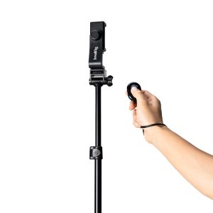 A hand holds a remote control pointing at the SmallRig 4363 Reverse Folding Live Streaming Stand Kit Encore PT 30, with the unit mounted against a white background.