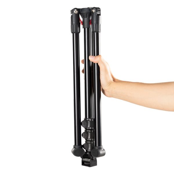 The hand holds the SmallRig 4363 Reverse Folding Live Streaming Stand Kit Encore PT 30, a black tripod with folding legs, isolated by a white background.