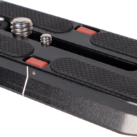 Sirui Quick Release Plate VP-SH15 -pikalevy on musta metallilevy, jossa on kuvioidut kumikahvat, useita ruuveja ja kaksi punaista painiketta, jotka on suunniteltu helpottamaan kameran kiinnittämistä jalustoihin.