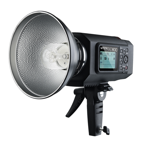 Godox Witstro AD600B Bowens Mount TTL on studiostroboskooppivalaisin, jossa on suuri hopeinen heijastin, digitaalinen näyttö, ohjauspainikkeet ja kiinnike jalustaan kiinnittämistä varten. Näytössä näkyvät asetukset ja "WITSTRO AD600" -merkintä.