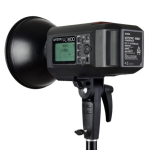 Musta Godox Witstro AD600B Bowens Mount TTL -studiostroboskooppivalaisin on asennettu jalustalle, ja sen sivussa on ohjauspainikkeet, LCD-näyttö ja tuotetiedot.