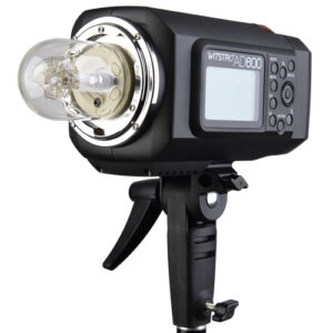 Godox Witstro AD600B Bowens Mount TTL-stroboskooppi on asennettu valotelineeseen, ja siinä on suuri lamppu ja digitaalinen ohjauspaneeli, jossa on useita painikkeita ja säätimiä.