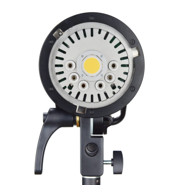 Lähikuva Godox H600P - AD600PRO ulkoisesta salamapäästä 600ws Bowens, jossa näkyy sen pyöreä metallipinta, jossa on ruuvinreiät ja keltainen keskivalopaneeli, asennettuna mustaan säädettävään jalustaan valkoista taustaa vasten.