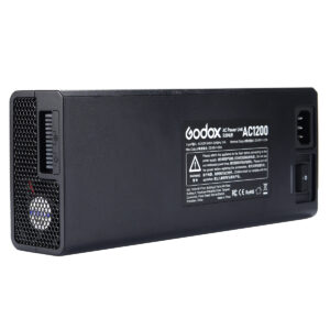 Suorakulmainen musta Godox AC-adapteri AD1200Pro, jossa on tuuletusaukko, virtakytkin ja merkintäpaneeli, jossa on tekniset tiedot ja sertifiointilogot toisella puolella.