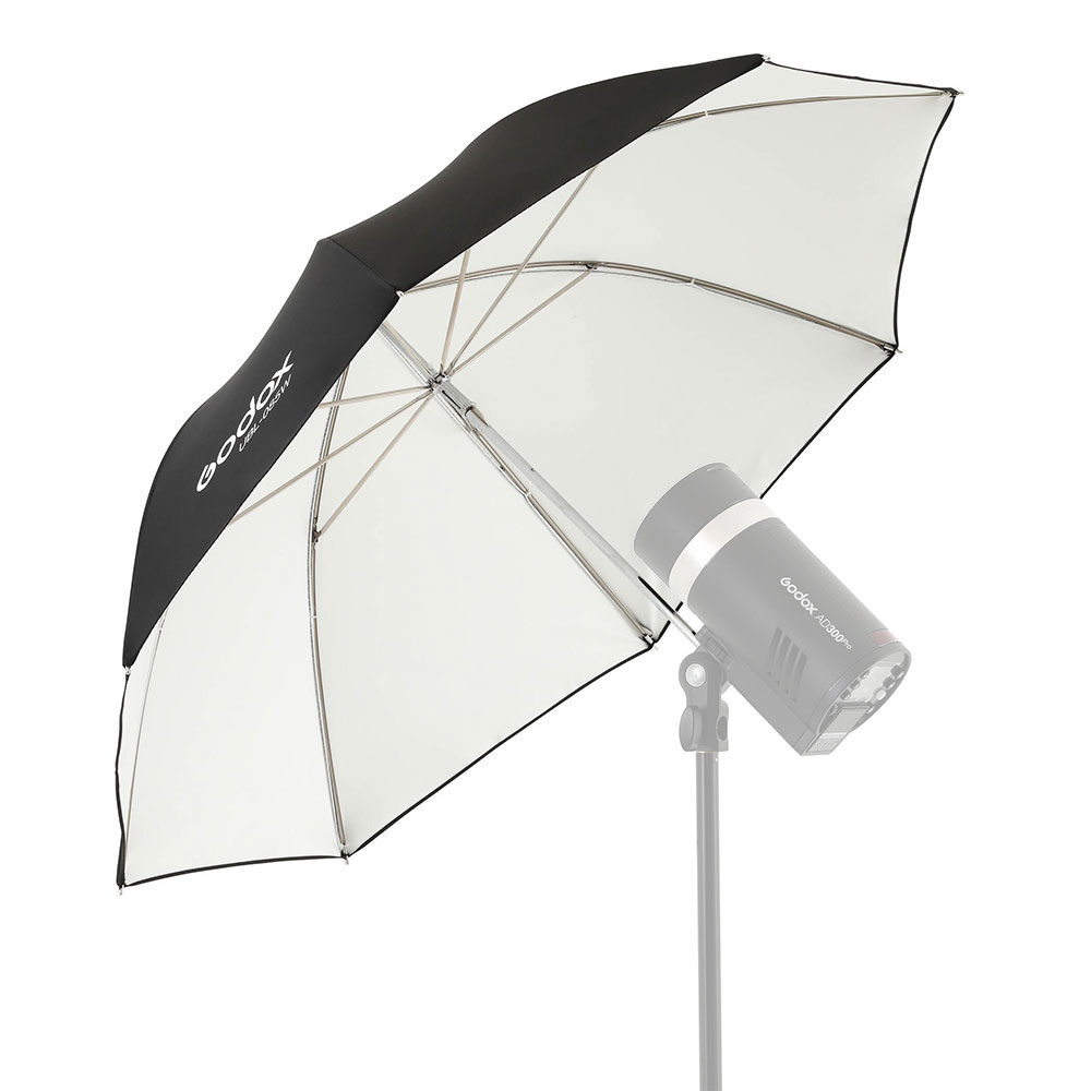Valokuvausstudiovalo, johon on kiinnitetty Godox White Umbrella 85cm for AD300Pro, on asetettu valotelineeseen valkoista taustaa vasten.
