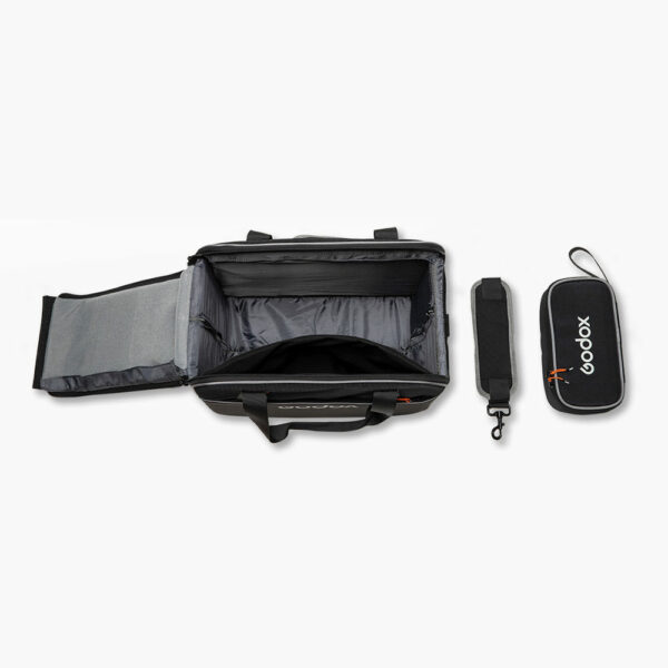 Godox Carry Bag for AD200 System on musta, suorakulmainen kameralaukku, jossa on avoin yläosa, irrotettava olkahihna ja sen vieressä vetoketjullinen tarvikepussi, kaikki vaaleanharmaalla pohjalla.