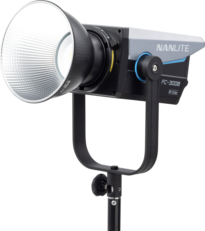 NANLITE FC-300B LED Bi-color Spot Light -LED-valo on asennettu mustaan jalustaan, jossa on suuri heijastinlautanen ja sininen korostus, kuvassa tavallista vaaleaa taustaa vasten.