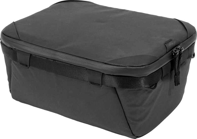 Peak Design Camera Cube V2 (S-Medium) on musta, suorakulmainen matkapussi, jossa on hieman pyöristetyt kulmat, sileä kangasrakenne, vetoketju ja pienet sivukahvat.