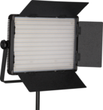 NANLITE 1200CSA Bicolor LED-paneeli on suorakulmainen studiovalo, jossa on säädettävät lato-ovet ja joka on asennettu jalustalle ja joka on ihanteellinen ammattimaiseen valokuvaukseen tai videokuvaukseen. Paneelissa on useita rivejä pieniä LED-valoja.