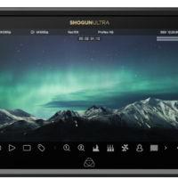 800q-02_126169 ATOMOS SHOGUN ULTRA 7-tuumainen HDR-monitori-tallennin 8K RAW näyttää lumisen vuoristomaiseman auroravalaistun yötaivaan alla, ja sen näytöllä näkyvät erilaiset tallennusasetukset ja kuvakkeet.