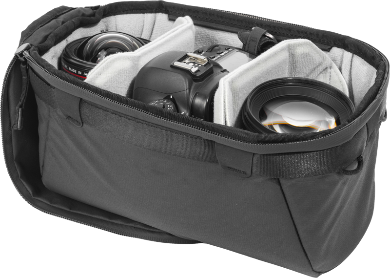 Mustan värinen Peak Design Camera Cube V2 (Small) on avattu, ja sen pehmustettuihin lokeroihin on kiinnitetty siististi DSLR-kamera ja kaksi objektiivia.