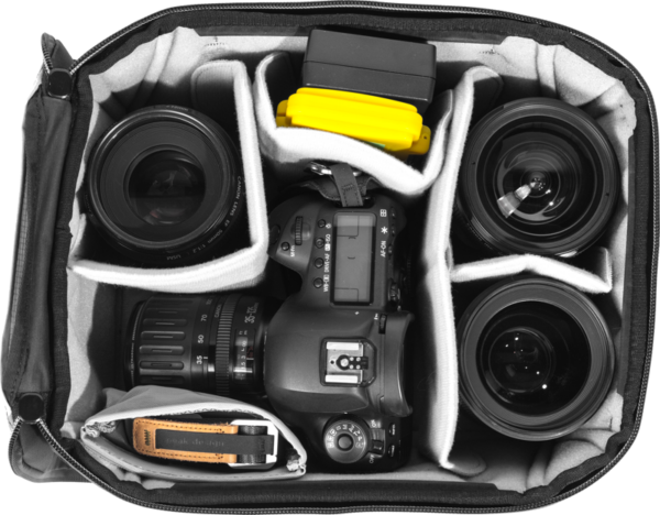 Peak Design Camera Cube V2 (S-Medium) -kamerakuutioon mahtuu DSLR-kamera, neljä objektiivia, keltainen lisävarustekotelo ja ruskea hihna, jotka kaikki on järjestetty yksittäisiin lokeroihin.
