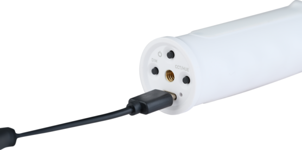 Close-up of the NANLITE USB-C to DMX Cable Splitter, a white cylindrical device charged by a black USB cable with control buttons marked DIM and CCT/Mode on one end.