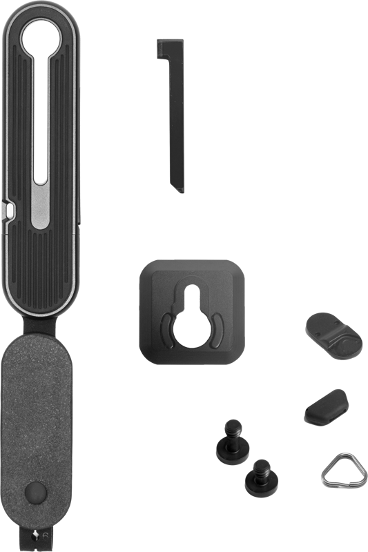 Peak Design Micro Clutch I-Plate, jossa on kiinnitysruuvit, pikakiinnityslevy, metallinen hihnarengas ja muita lisävarusteita, on järjestetty siististi valkoiselle taustalle.