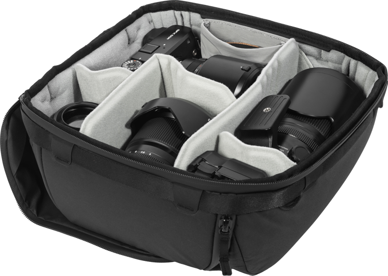 Peak Design Camera Cube V2 (Medium) on musta kameralaukku, jossa on pehmustetut väliseinät ja joka pitää kameran rungon, useita objektiiveja ja lisävarusteet siististi järjestyksessä erillisissä lokeroissa.