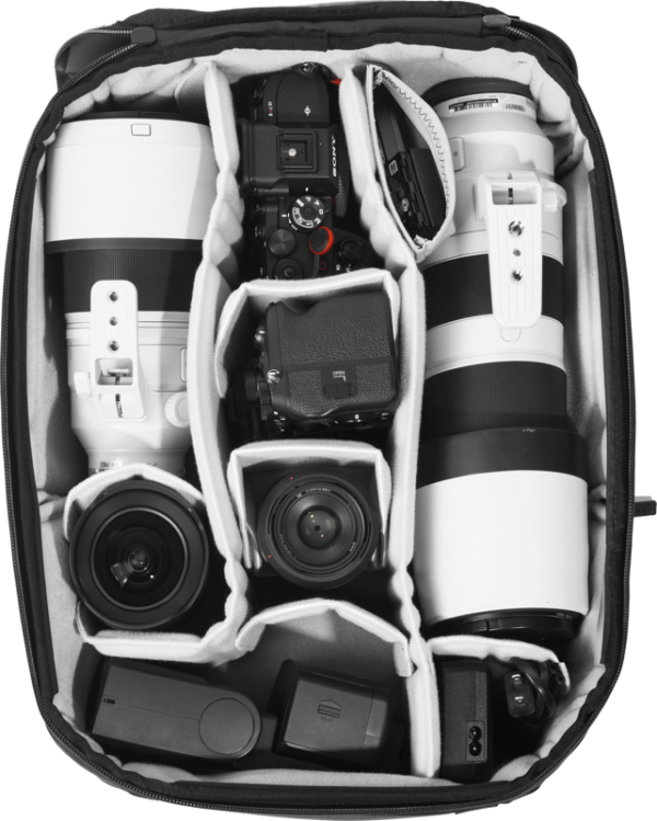 Ylhäältä alaspäin katsottuna Peak Design Camera Cube V2 (Large), joka on pakattu siististi kameroille, suurille ja pienille objektiiveille sekä lisävarusteille, jotka on järjestetty yksittäisiin lokeroihin.