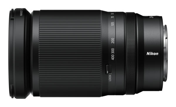 Musta Nikon Nikkor Z 28-400mm f/4-8 VR -objektiivi, jossa on zoomausmerkinnät, kuvioitu kahva, lukituskytkin ja Nikonin tuotemerkki sivulla, näkyy valkoisella taustalla.