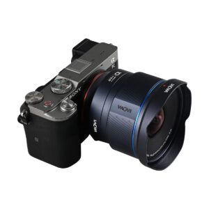Digitaalinen peilitön kamera, jossa on hopeinen päällinen ja musta kahva, näkyy valkoista taustaa vasten, ja sen parina on Laowa Sony FE AF 10mm f/2.8 Zero-D FF -laajakulmaobjektiivi.