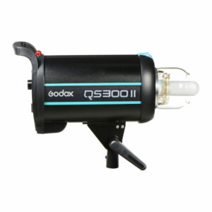 Godox QS300II (Bowens) -studiostroboskooppivalaisin mustana, kirkkaalla polttimolla ja kiinnikkeellä, kuvattuna sivulta valkoista taustaa vasten.