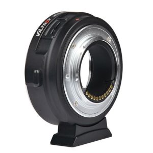 Viltrox EF-M1 Autofocus Adapterissa on musta runko, jossa on hopeinen metallirengas, ja se seisoo pystyssä pienellä jalustalla, jonka avulla voit liittää kameran objektiivit eri kamerarunkoihin.