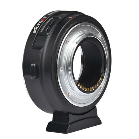 Viltrox EF-M1 Autofocus Adapterissa on musta runko, jossa on hopeinen metallirengas, ja se seisoo pystyssä pienellä jalustalla, jonka avulla voit liittää kameran objektiivit eri kamerarunkoihin.