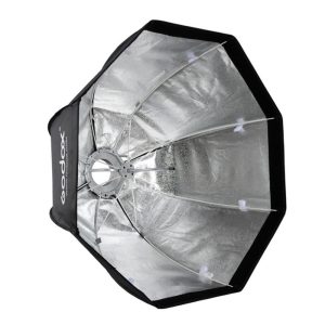 The Godox SB-GUE120 Umbrella Softbox Bowens 120cm with Grid is a silver-coloured reflective light converter with black edges for photography, presented open and angled to reveal its internal structure and metallic surface.