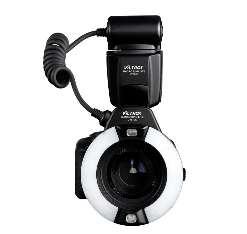 Ammattikäyttöön tarkoitettu kamera, jossa on objektiivin ympärille asennettu Viltrox JY 670C Canon Ringflash -salama, joka on kytketty kierrekaapelilla kameran päällä olevaan ohjausyksikköön.