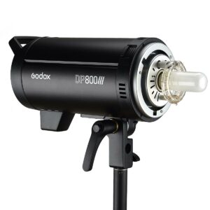Musta Godox DP800III -studiostroboskooppivalaisin, jossa on näkyvä kirkas lamppu, asennettu jalustalle ja kuvattu valkoista taustaa vasten.