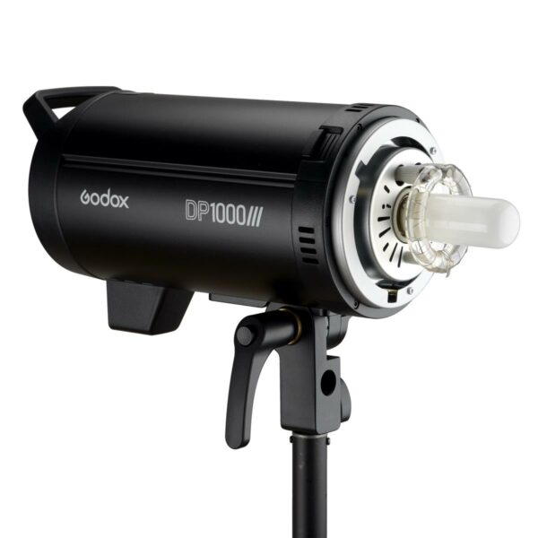 Musta Godox DP1000III -studiostroboskooppivalaisin on asennettu jalustalle, ja sen sylinterimäinen runko, avoin lamppu ja säädettävä kiinnike näkyvät valkoista taustaa vasten.