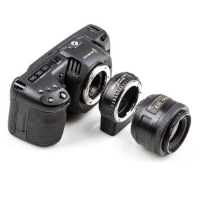 Blackmagic Pocket Cinema Camera, jonka objektiivikiinnitys on paljastettu, Viltrox Nikon F-M1 -objektiivin kiinnityssovitin ja irrotettu Nikon-kameran objektiivi näkyvät valkoisella pohjalla.