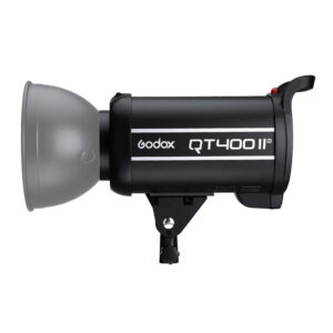Musta Godox QT400II M -studiostroboskooppivalaisin, jossa on harmaa heijastin ja kiinnitysteline, näkyy sivukuvassa valkoista taustaa vasten.