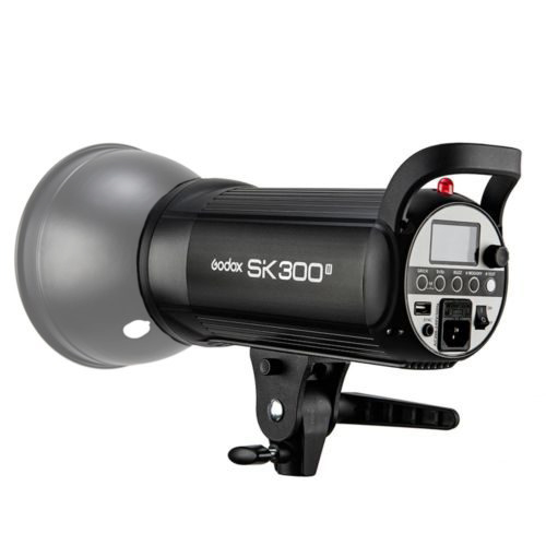 Mustaa Godox SK300II -studiostroboskooppivalaisinta, jossa on digitaalinen näyttö ja ohjauspainikkeet, näytetään kiinnitettynä kiinnikkeeseen kulmasta, joka paljastaa sekä sen etu- että sivupuolen.