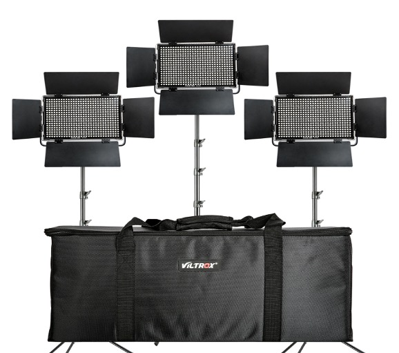 Three Viltrox VL D60T LED panel luminaires with adjustable barn doors are mounted on a stand behind a large black carrying case. These lights and the housing form a trio of Viltrox VL D60T LED lights.