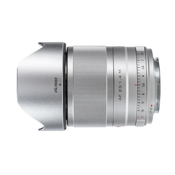 Hopeinen Viltrox AF 23mm f/1.4 -objektiivi Fuji X:lle, kuvassa huppu, manuaali-/automaattitarkennustilat, näkyvät aukkomerkinnät ja uurrettu tarkennusrengas, kuvattu valkoisella taustalla.