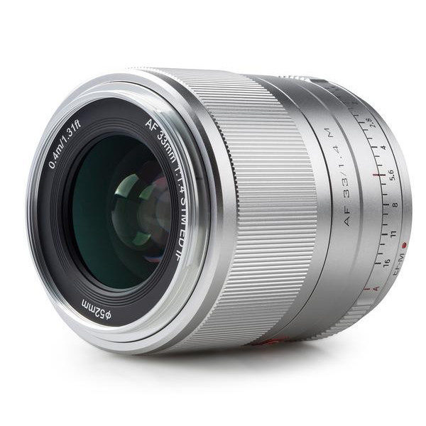 Silver Viltrox AF 33mm f/1.4 lens for Fuji X with brushed focus ring, 52mm filter thread, distance and aperture scales and clear AF 33mm f/1.4 markings on the side.