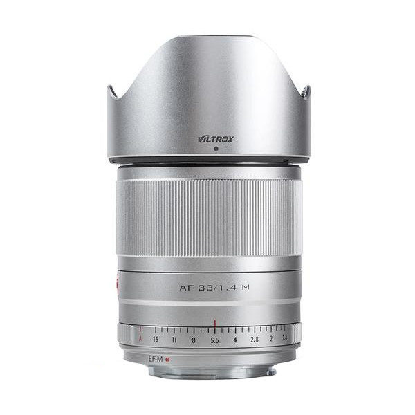 The silver Viltrox AF 33mm f/1.4 lens for Fuji X stands upright against a white background, with a focus ring and backlight protection.