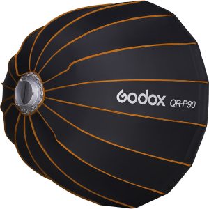 Musta Godox Quick Release Parabolic Softbox QR P90 Bowens, jossa on oranssit saumat ja hopeinen kiinnitysrengas studiokuvaukseen. Godoxin logo ja mallinimi näkyvät valkoisella kyljessä.