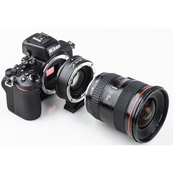 Nikon-kameran runko on liitetty Viltrox EF - Z2 Speed Boosteriin, joka on kiinnitetty suureen kameran objektiiviin, kaikki valkoisella taustalla.