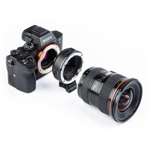 Sony Alpha camera, Viltrox EF - Sony E adapter and camera lens are lined up on a white background, with the adapter placed between the camera and lens.