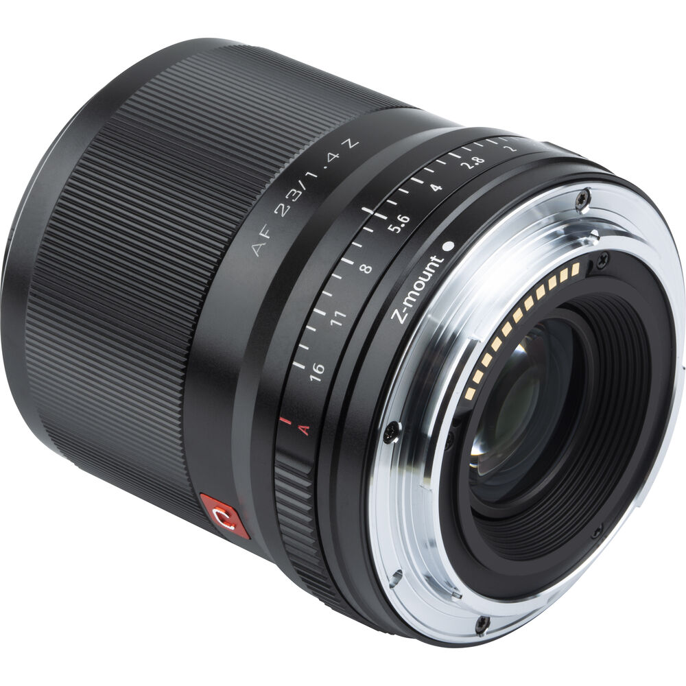 Nikon Z:lle tarkoitetun Viltrox AF 23mm f/1.4 -objektiivin lähikuvassa näkyy sen musta runko, jossa on hopeisia ja punaisia yksityiskohtia, automaattitarkennusrengas, aukkomerkinnät ja Z-kiinnike kameran kiinnitystä varten.