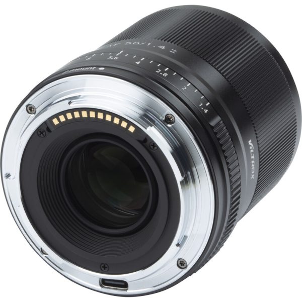 Nikon Z:lle tarkoitetun Viltrox AF 56mm f/1.4 -objektiivin lähikuvassa näkyvät sen metallinen objektiivikiinnitys, elektroniset koskettimet ja aukon merkinnät tyylikkäässä mustassa tynnyrissä.