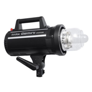 The Godox GS300II is a black studio strobe light with handle, control knobs and a clear cover on the flash tube, mounted on a tripod bracket.