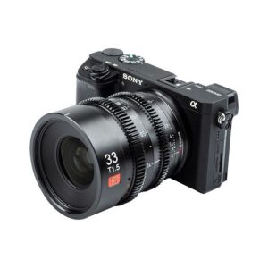 Musta Sony Alpha -peilitön kamera, johon on kiinnitetty Viltrox MF 33mm T1.5 Cine Lens -objektiivi (Sony E), katsottuna pienessä kulmassa valkoista taustaa vasten.