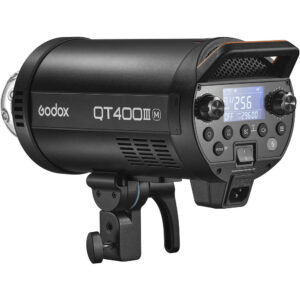 Musta Godox QT400IIIM-stroboskooppivalaisin, jossa on digitaalinen näyttö, ohjauspainikkeet ja kiinnitysteline, pienestä kulmasta katsottuna.