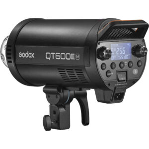 Musta Godox QT600IIIM -studiostroboskooppivalaisin, jossa on ohjauspainikkeet, digitaalinen näyttö ja kiinnitysteline, näkyy sivulta valkoista taustaa vasten.