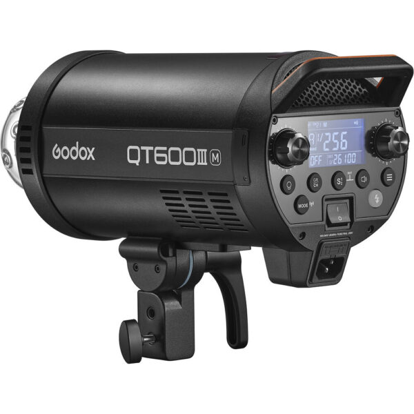 Musta Godox QT600IIIM -studiostroboskooppivalaisin, jossa on ohjauspainikkeet, digitaalinen näyttö ja kiinnitysteline, näkyy sivulta valkoista taustaa vasten.