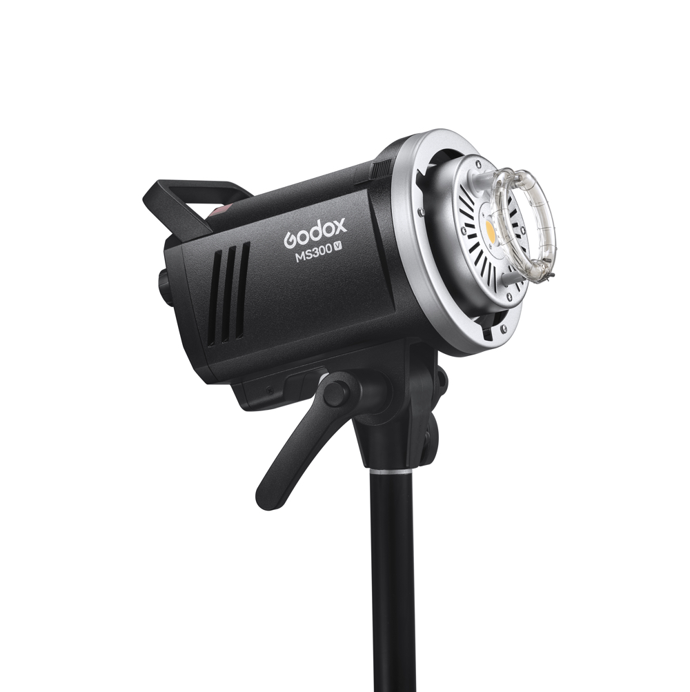 Godox MS300V -studiostroboskooppivalaisin on asennettu mustalle jalustalle, ja se on kallistettu siten, että sen säätimet ja kiinnike näkyvät valkoista taustaa vasten.